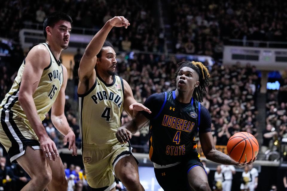 Morehead State guard Eddie Ricks III (4) shoots around Purdue center Zach Edey (15) and forward Trey Kaufman-Renn (4) during the first half of an NCAA college basketball game in West Lafayette, Ind., Friday, Nov. 10, 2023. (AP Photo/Michael Conroy)