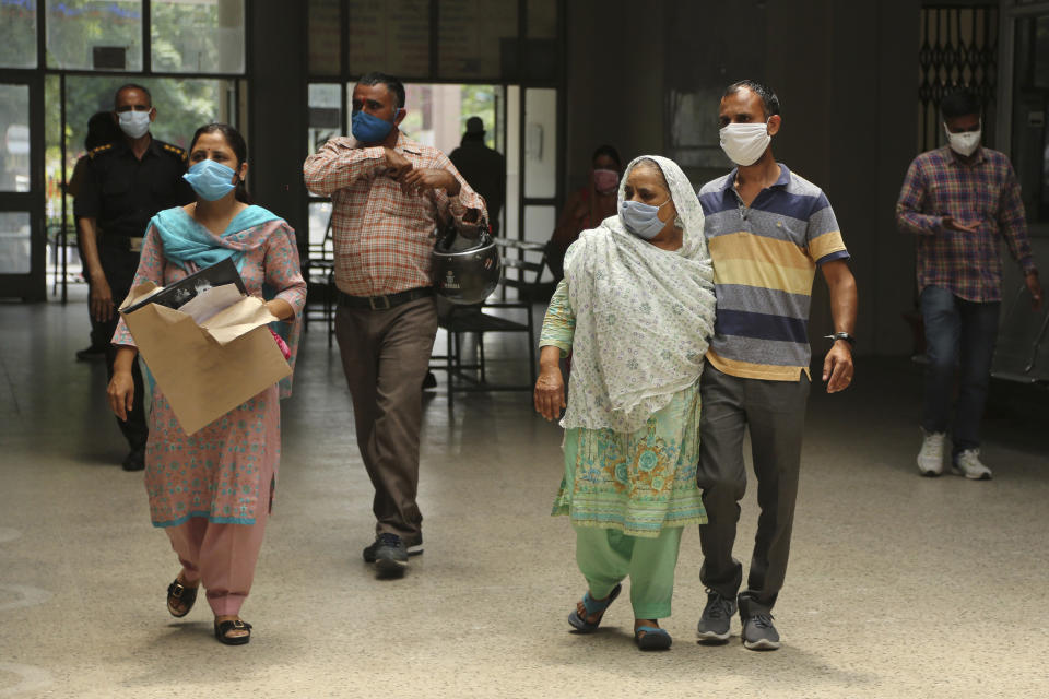 Indians wearing face masks arrive to consult doctors at COVID-19 screening facility inside a government run hospital in Jammu, Saturday, June 27, 2020. India is the fourth hardest-hit country by the pandemic in the world after the U.S., Russia and Brazil. (AP Photo/Channi Anand)