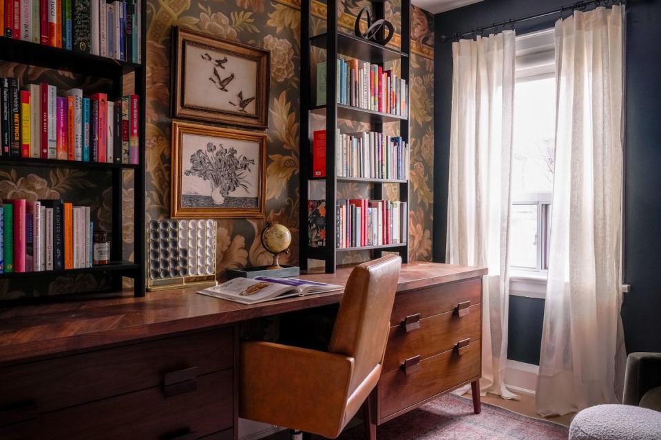 a desk with a bookcase and a clock on it