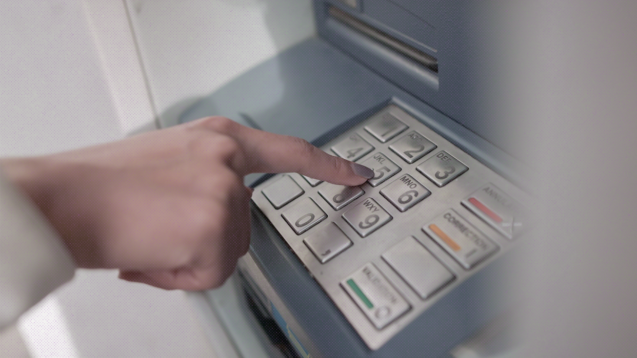a photo of a hand over an ATM pin pad