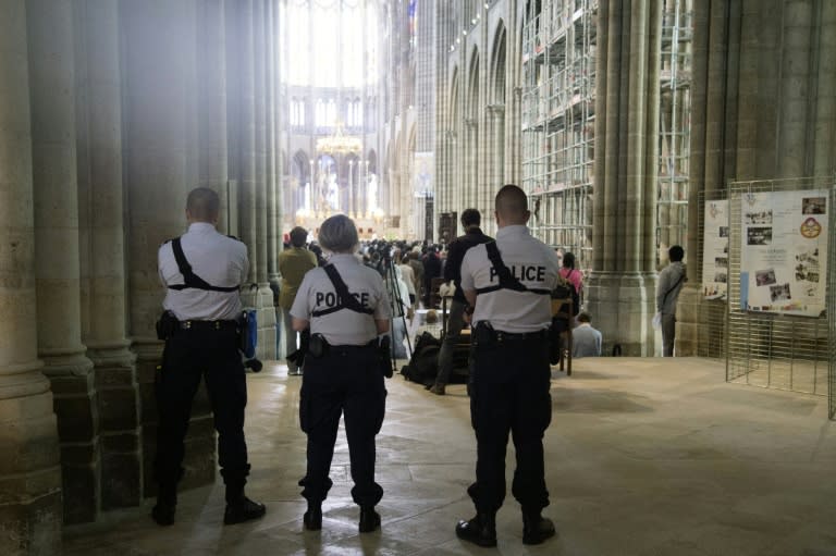 Police officers stand guard during mass in Saint-Denis Cathedral on July 31, 2016