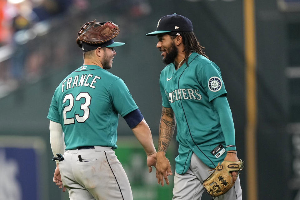 Seattle Mariners' Ty France (23) and J.P. Crawford celebrate after a baseball game against the Houston Astros Sunday, Aug. 22, 2021, in Houston. The Mariners won 6-3 in 11 innings. (AP Photo/David J. Phillip)