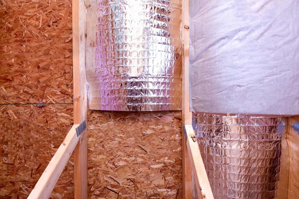 A close up shot shows a radiant barrier installed on a wall.