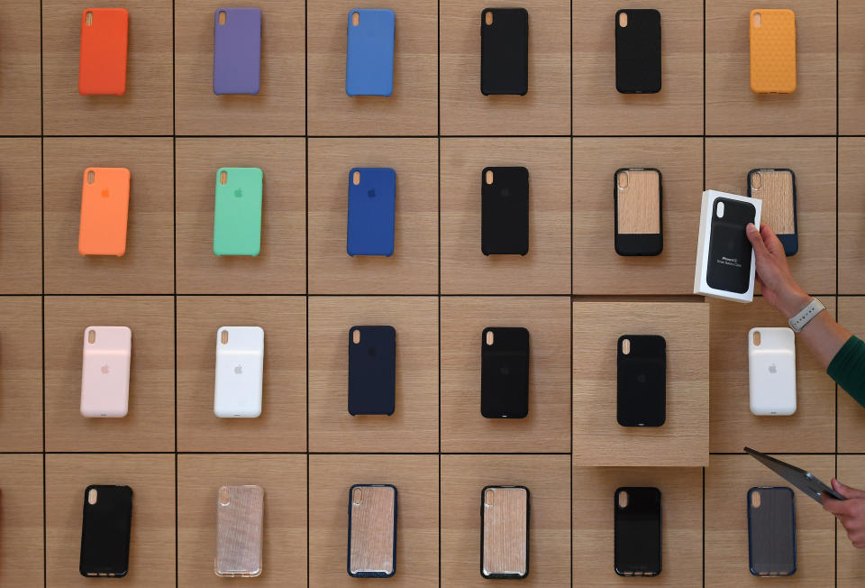 An Apple Store employee takes an iPhone product out of a drawer during the grand opening and media preview of the new Apple Carnegie Library store in Washington, U.S., May 9, 2019. REUTERS/Clodagh Kilcoyne