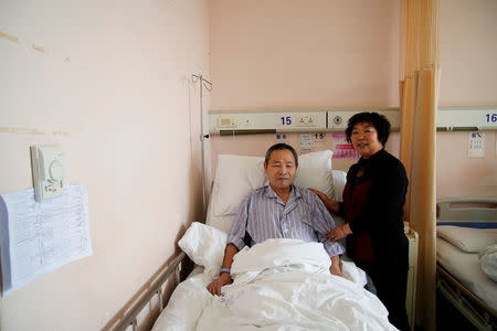 Huang Chenfeng (R), 63, and her husband Zheng Dingguo, 63, pose for a picture at Fudan University Shanghai Cancer Center in Shanghai, China, February 6, 2018. Both originally come from Wenzhou in Zhejiang province. Huang has been taking care of her husband around the clock since he was admitted to the hospital for cancer treatment. The couple had an arranged marriage, organised by their parents in 1972. REUTERS/Aly Song