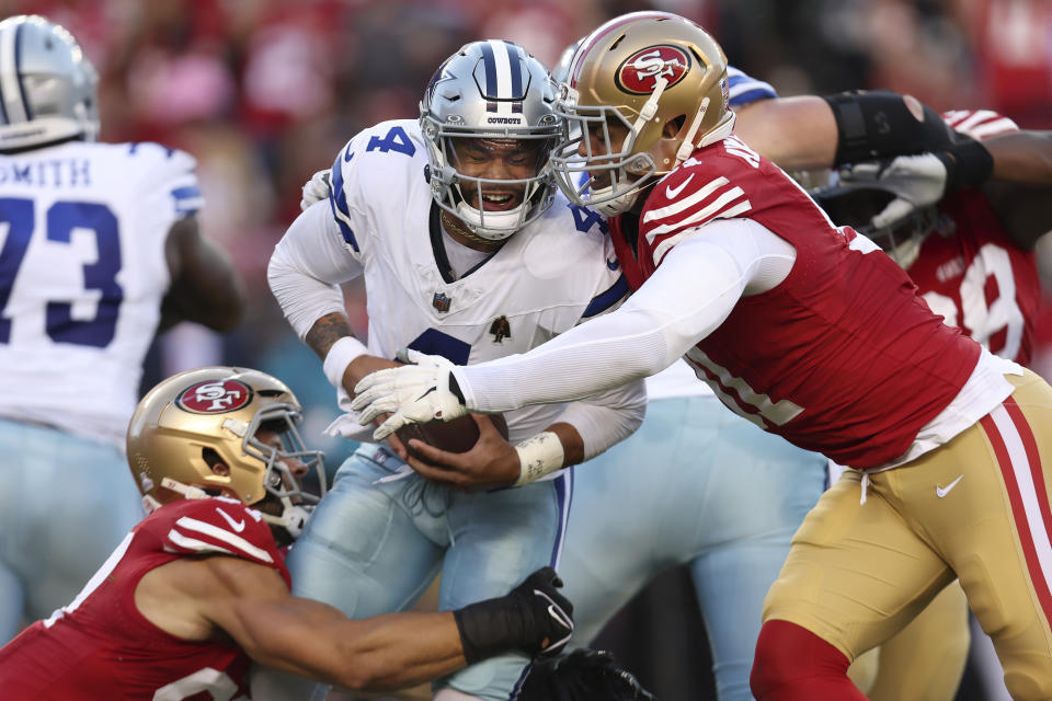 Dallas Cowboys quarterback Dak Prescott, middle, is sacked by San Francisco 49ers defensive end Nick Bosa, left, and defensive end Arik Armstead during the first half of an NFL football game in Santa Clara, Calif., Sunday, Oct. 8, 2023. (AP Photo/Jed Jacobsohn)