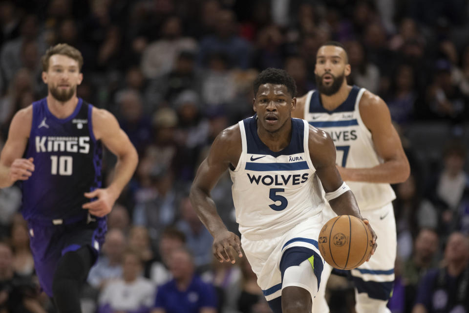 Minnesota Timberwolves guard Anthony Edwards (5) starts a fast break as teammate Rudy Gobert, right, and Sacramento Kings forward Domantas Sabonis (10) pursue in the first quarter of an NBA basketball game in Sacramento, Calif., Saturday, Dec. 23, 2023. (AP Photo/José Luis Villegas)