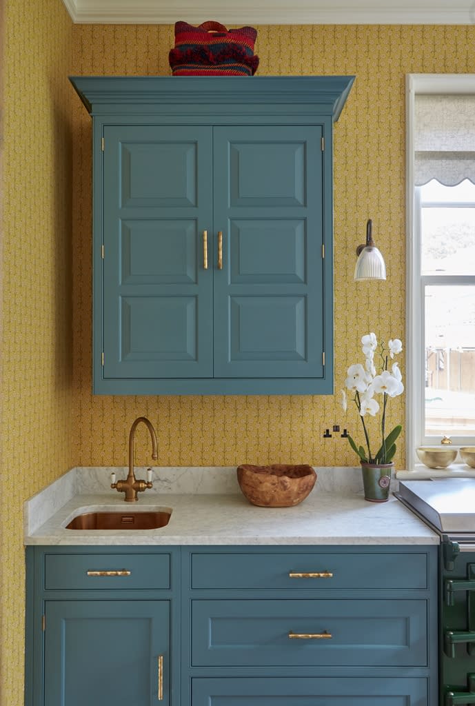 Blue and yellow kitchen with  floral print wallpaper