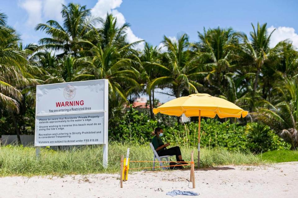 A beach attendant works near the border of Golden Beach and Sunny Isles Beach. The sign and the attendant tell visitors that Golden Beach is a private beach restricted to the town’s property owners.