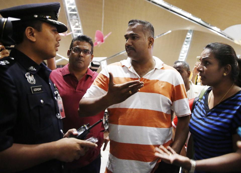 People, who said they believed their relatives were on Malaysia Airlines flight MH17, speak to a police officer for more information about the crashed plane at Kuala Lumpur International Airport in Sepang July 18, 2014. The Malaysia Airlines Boeing 777 was brought down over eastern Ukraine on Thursday, killing all 295 people aboard and sharply raising the stakes in a conflict between Kiev and pro-Moscow rebels in which Russia and the West back opposing sides. REUTERS/Olivia Harris (MALAYSIA - Tags: TRANSPORT DISASTER POLITICS)