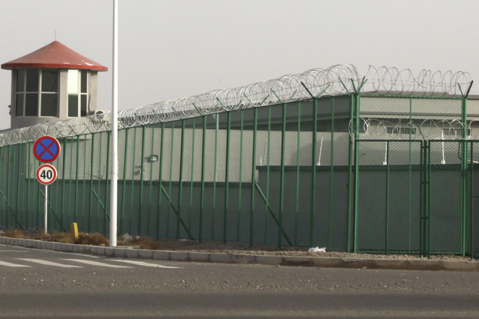 FILE - In this Monday, Dec. 3, 2018, file photo, a guard tower and barbed wire fence surround a detention facility in the Kunshan Industrial Park in Artux in western China's Xinjiang region. The Associated Press has found that the Chinese government is carrying out a birth control program aimed at Uighurs, Kazakhs and other largely Muslim minorities in Xinjiang, even as some of the country's Han majority is encouraged to have more children. The measures include detention in prisons and camps, such as this facility in Artux, as punishment for having too many children. (AP Photo/Ng Han Guan, File)