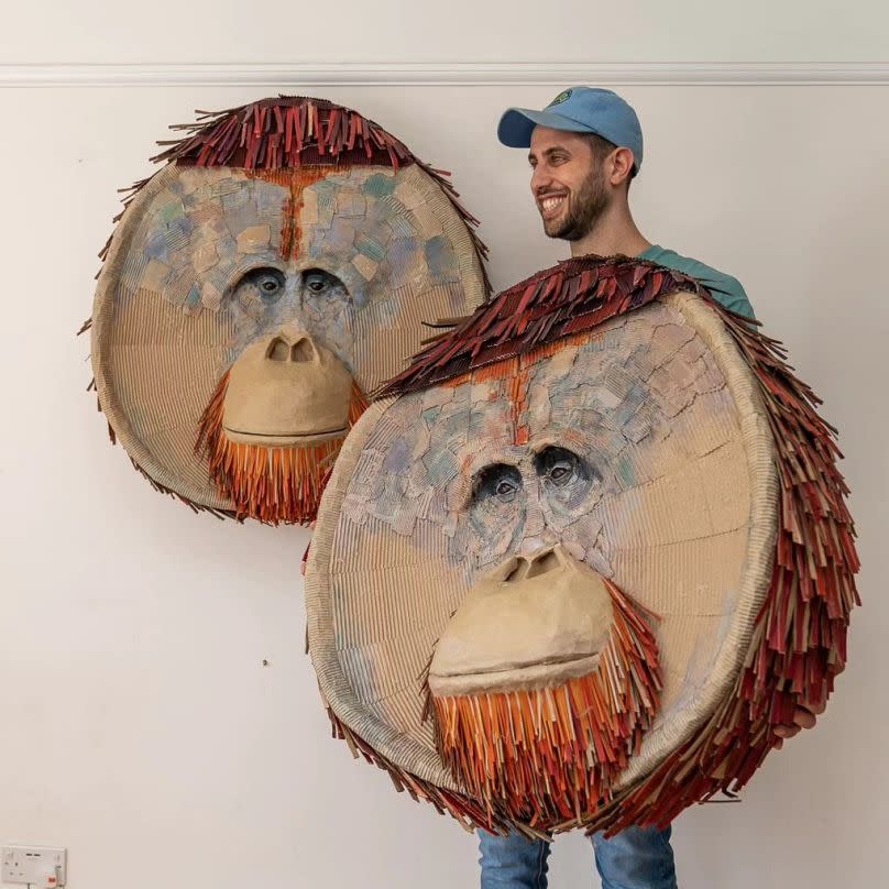 Josh Gluckstein pictured with two of his orangutan head sculptures 