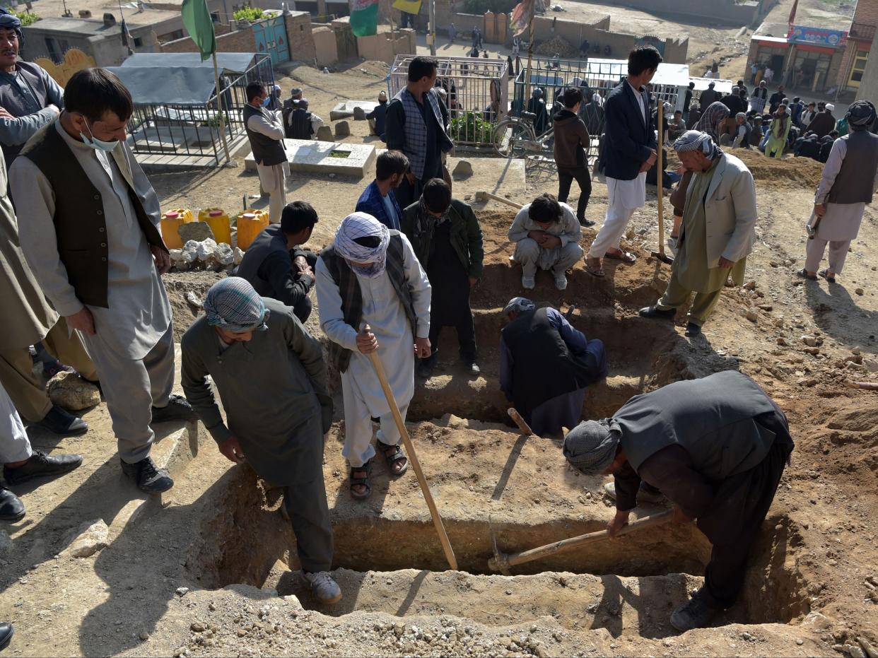 Shiite mourners and relatives dig graves for schoolgirls who died in multiple blasts outside a school in Kabul (AFP via Getty Images)