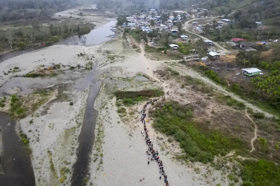 Migrants line up to take a boat to Lajas Blancas in Bajo Chiquito, Darien Province, Panama Sunday, May 7, 2023. Thousands of migrants who walk across the Darien Gap from Colombia exit the jungle at Bajo Chiquito. (AP Photo/Natacha Pisarenko)