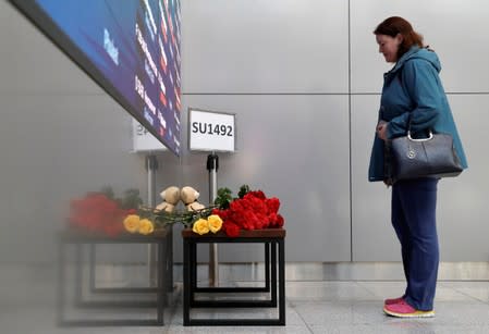 FILE PHOTO: A woman commemorates victims of an incident involving an Aeroflot Sukhoi Superjet 100 passenger plane at Moscow's Sheremetyevo airport