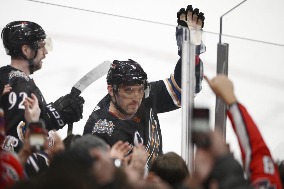 Washington Capitals left wing Alex Ovechkin (8) waves to the crowd as he was recognized for scoring his 801st NHL goal during the first period of an NHL hockey game against the Winnipeg Jets, Friday, Dec. 23, 2022, in Washington. (AP Photo/Nick Wass)