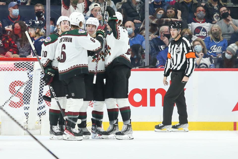 Nov 29, 2021; Winnipeg, Manitoba, CAN;  Arizona Coyotes forward Antoine Roussel (26) is congratulated by his team mates on his goal against the Winnipeg Jets during the second period at Canada Life Centre.