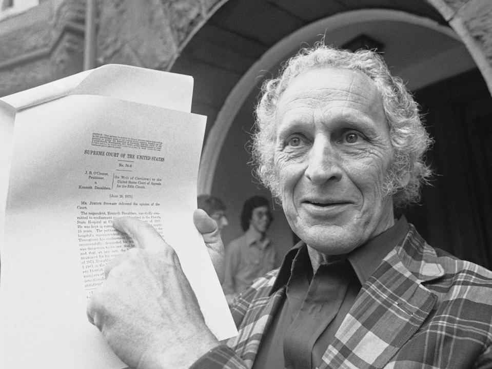 Kenneth Donaldson holds a copy of a Supreme Court opinion in 1975.