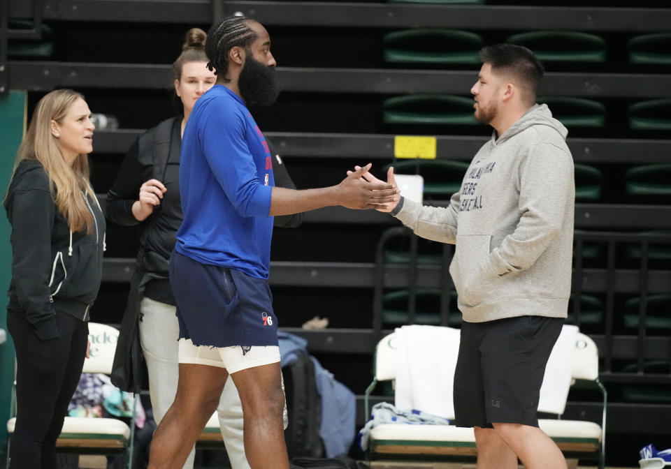 Philadelphia 76ers guard James Harden, left, greets Brandon Chinn, 76ers Director of Basketball Communications, during the NBA basketball team's practice on Thursday, Oct. 5, 2023, in Fort Collins, Colo. (AP Photo/David Zalubowski)