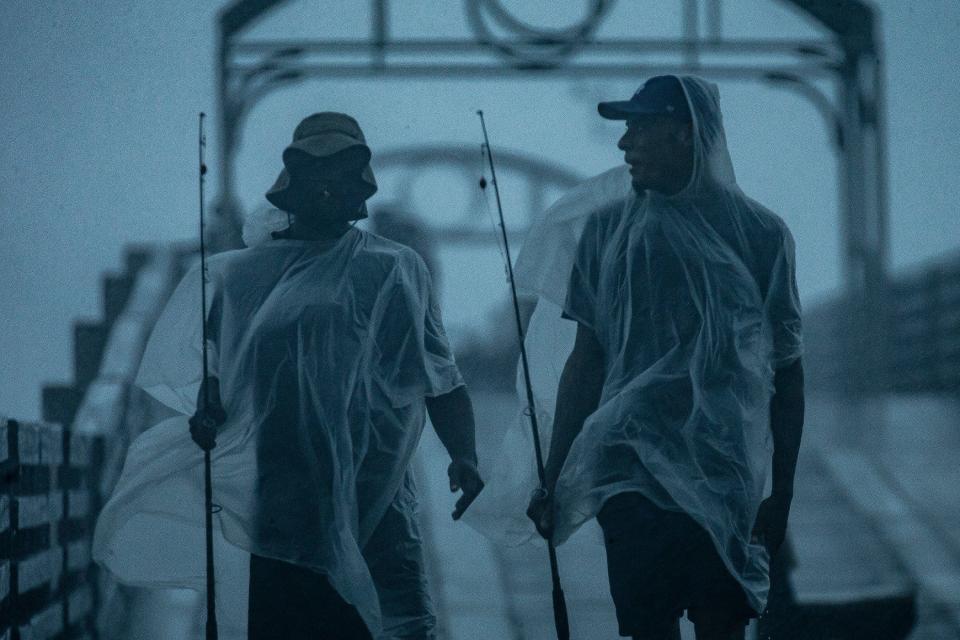 Mike Jones and Joshua Ross, both of Boynton Beach, walk off the William O. Lockhart Pier as rain fell in Lake Worth Beach, Fla., on June 12, 2024.