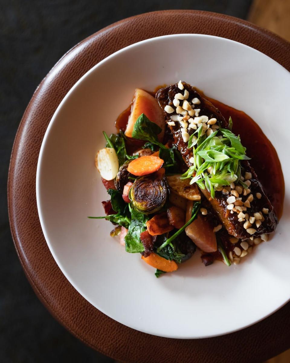 Jake&#x002019;s on the Lake &#39;s braised piedmontese short ribs with root vegetables, heirloom spinach, pancetta, macadamia nuts, and ginger-chili glaze.