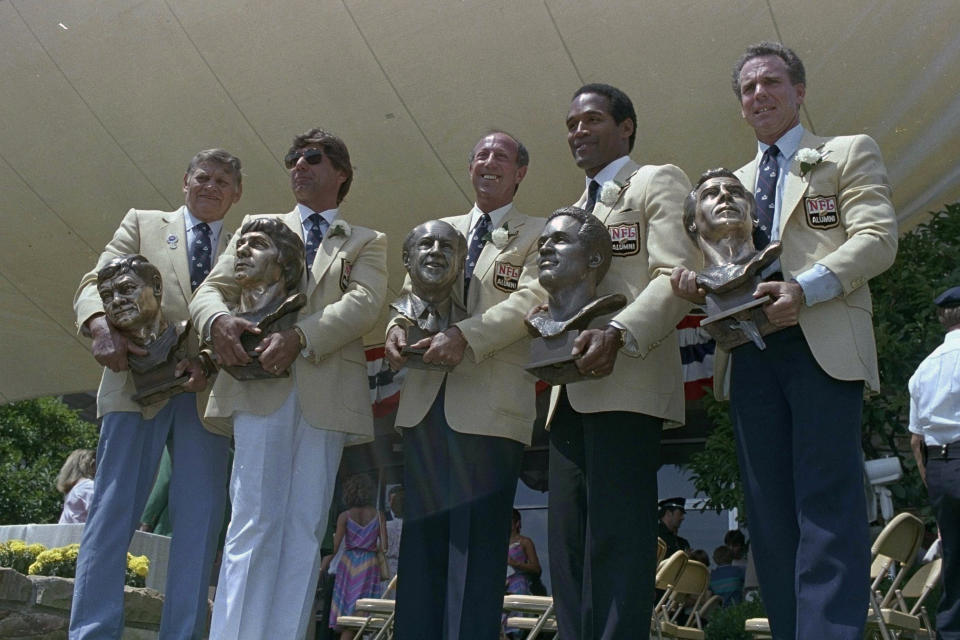 FILE - O.J. Simpson, second from right is joined by, from left, Frank Gatski, Joe Namath, Pete Rozelle, and Roger Staubach, right, during enshrinement ceremonies at the Pro Football Hall of Fame in Canton, Ohio, Aug. 3, 1985. O.J. Simpson, the decorated football superstar and Hollywood actor who was acquitted of charges he killed his former wife and her friend but later found liable in a separate civil trial, has died. He was 76. (AP Photo/Ernie Mastroianni, File)