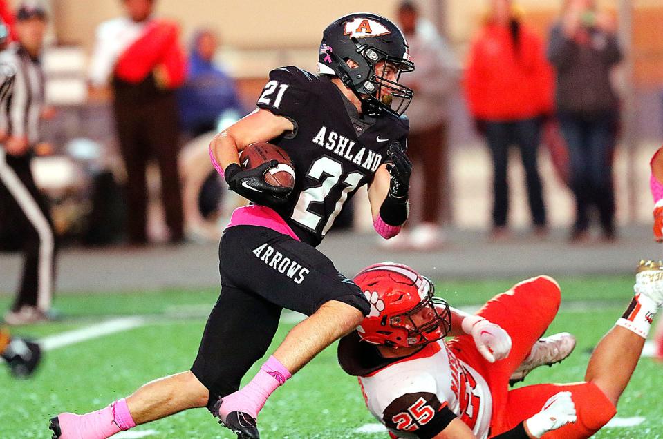 Ashland High School's Jon Metzger (21) turns up field past Mansfield Senior High School's Mekhi Bradley (25) on a first quarter reception during high school football action at Community Stadium Friday, Sept. 30, 2022. TOM E. PUSKAR/ASHLAND TIMES-GAZETTE