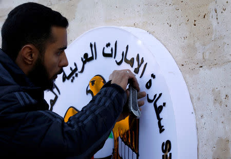 FILE PHOTO: A man works on the United Arab Emirates embassy emblem during its reopening in Damascus, Syria December 27, 2018. REUTERS/Omar Sanadiki/File Photo