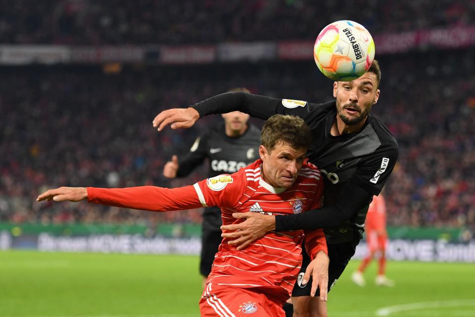 Bayern Munich's German forward Thomas Mueller (L) and Freiburg's German defender Manuel Gulde vie for the ball during the German Cup (DFB Pokal) quarter-final football match FC Bayern Munich v SC Freiburg in Munich southern Germany on April 4, 2023. (Photo by Christof STACHE / AFP) / DFB REGULATIONS PROHIBIT ANY USE OF PHOTOGRAPHS AS IMAGE SEQUENCES AND QUASI-VIDEO. (Photo by CHRISTOF STACHE/AFP via Getty Images)