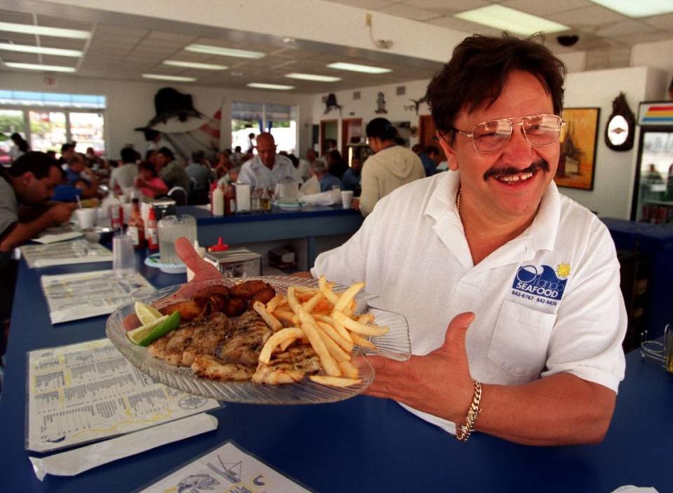 Orlando Gay, a Cuban exile, is Cynthia Bowles father. In this 2001 photo, he’s serving food at his Orlando’s Seafood restaurant in Miami.