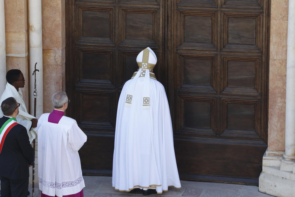 Pope Francis opens the Holy Door of St. Mary in Collemaggio Basilica and start the jubilee of forgiveness, in L'Aquila, central Italy, Sunday, Aug. 28, 2022. Pope Francis will be the first pope since Celestine V to open this Holy Door, the first in history, established with the Bull of Forgiveness of 29 September 1294 by Pope Celestine V. (AP Photo/Riccardo De Luca)