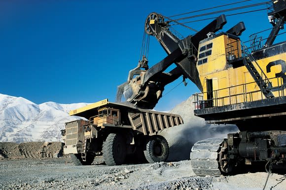 An excavator loading a dump truck in an open-pit mine.