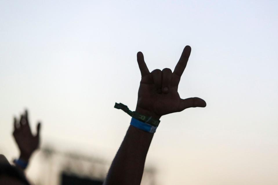 A fan holds a hand in the air as The Black Crowes perform on the Mane Stage during the Stagecoach country music festival in Indio, Calif., Sunday, May 1, 2022.