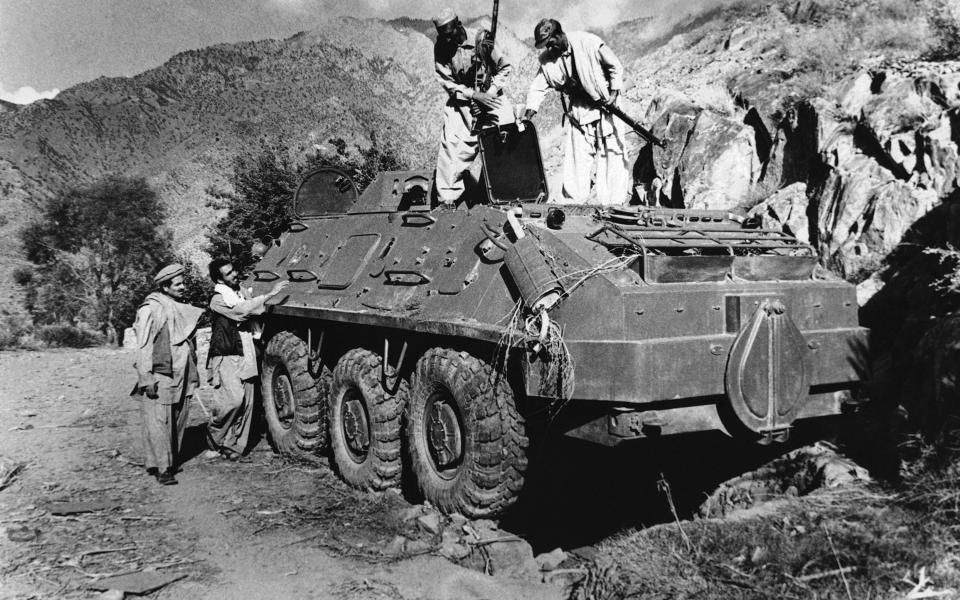 FILE - In this Dec. 27, 1979 file photo, rebel Muslim fighters inspect a Soviet tank captured in fighting with the Kabul government forces on September near Asmar, Afghanistan. The Soviet invasion of Afghanistan and other climactic events in 1979, which dominated television sets and newspaper front pages 40 years ago, helped shape the modern Middle East. (AP Photo/Steve McCurry, File)