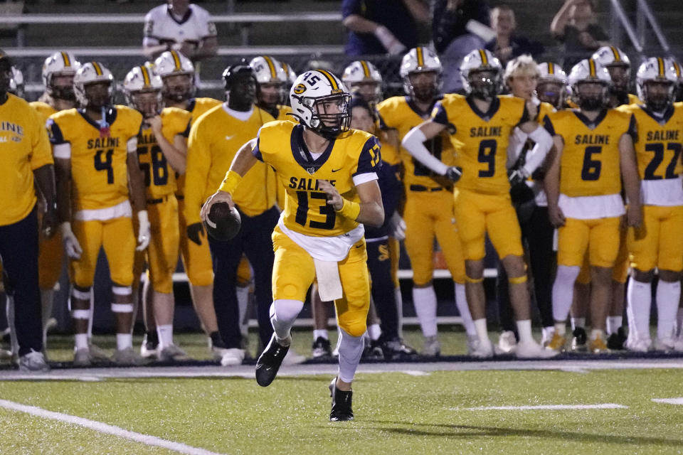 Saline High School quarterback CJ Carr (13) plays during a football game Friday, Oct. 27, 2023, in Saline, Mich. Carr will be among the hundreds of football players to sign a national letter of intent this week, sealing his commitment to join Notre Dame, but no one has a story quite the same. (AP Photo/Carlos Osorio)