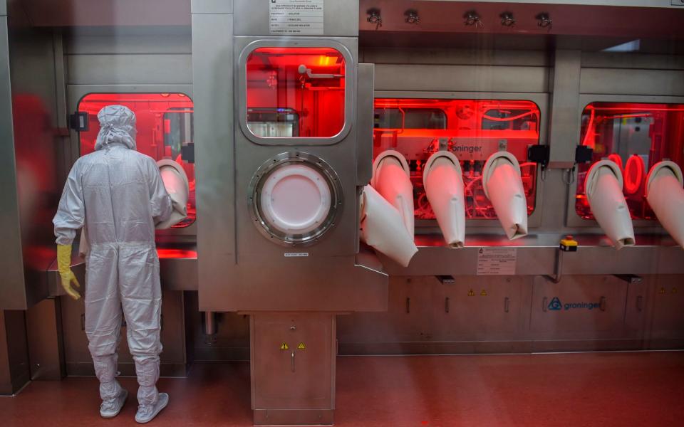 An employee works on an assembly line for manufacturing vials of Covishield at India's Serum Institute - AFP