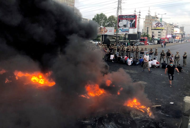 Demonstrators sit together during a protest over deteriorating economic situation, in the city of Jounieh