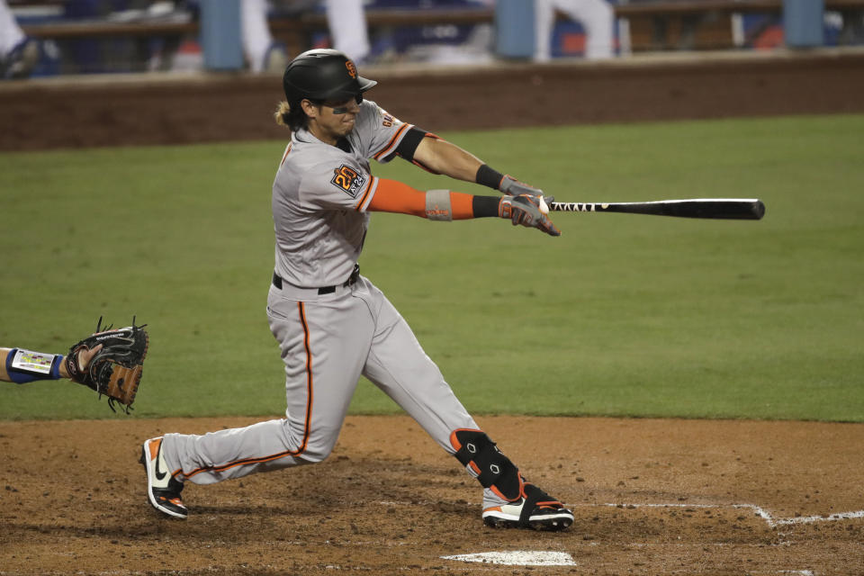 San Francisco Giants' Mauricio Dubon hits an RBI single during the sixth inning of a baseball game against the Los Angeles Dodgers, Sunday, July 26, 2020, in Los Angeles. (AP Photo/Jae C. Hong)