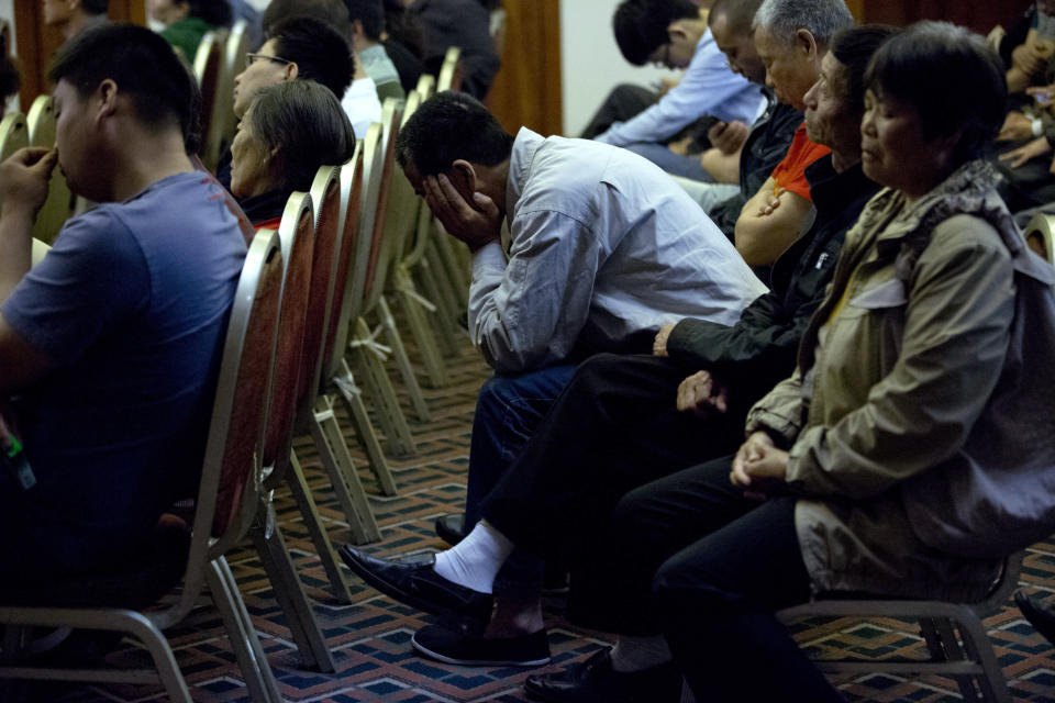 Relatives of Chinese passengers onboard the missing Malaysia Airlines Flight 370 listen, as part of the audio communications between Flight 370's cockpit and air traffic controllers is played, during a meeting with Malaysian officials at a hotel in Beijing, China, Wednesday, April 30, 2014. The Australian agency heading up the search for the missing Malaysian jet has dismissed a claim by a resource survey company that it found possible plane wreckage in the northern Bay of Bengal. (AP Photo/Alexander F. Yuan)