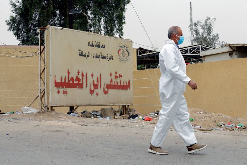 A medical staff member walks near the main entrance of Ibn Khatib hospital where a fire was sparked by an oxygen tank explosion, in Baghdad