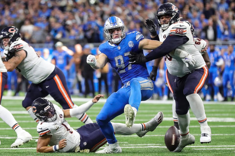 Detroit Lions defensive end Aidan Hutchinson (97) and Chicago Bears offensive tackle Darnell Wright (58) battle for the ball after Chicago Bears quarterback Justin Fields (1) is forced to fumble by Hutchinson during the second half at Ford Field in Detroit on Sunday, Nov. 19, 2023