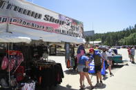 People shop for Trump memorabilia in Keystone, S.D. on Friday, July 3, 2020 ahead of a fireworks display at Mount Rushmore the president is expected to attend. (AP Photo/Stephen Groves)