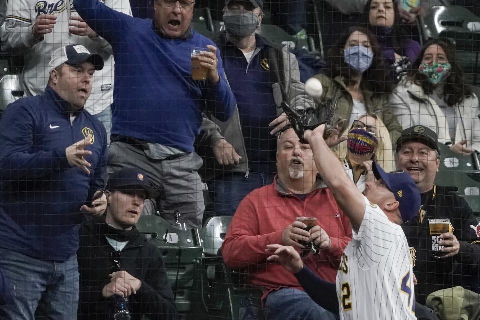 Fans watch as Milwaukee Brewers' Travis Shaw catches a foul ball hit by Pittsburgh Pirates' Gregory Polanco during the fourth inning of a baseball game Friday, April 16, 2021, in Milwaukee. (AP Photo/Morry Gash)