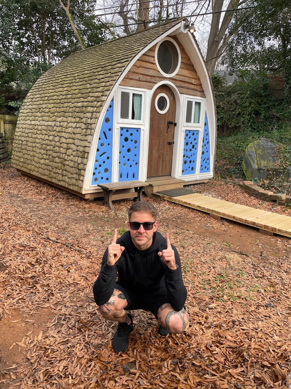 Writer Mike Goldys poses in front of Maryann O’Keeffe’s boathouse in Charlotte, N.C. It was the 11th property on his tiny home tour.