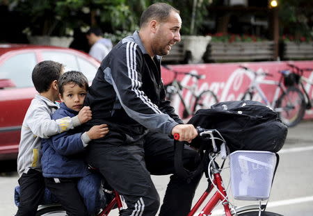 Migrants from Syria ride their bicycles near the Greek border in Macedonia June 17, 2015. REUTERS/Ognen Teofilovski