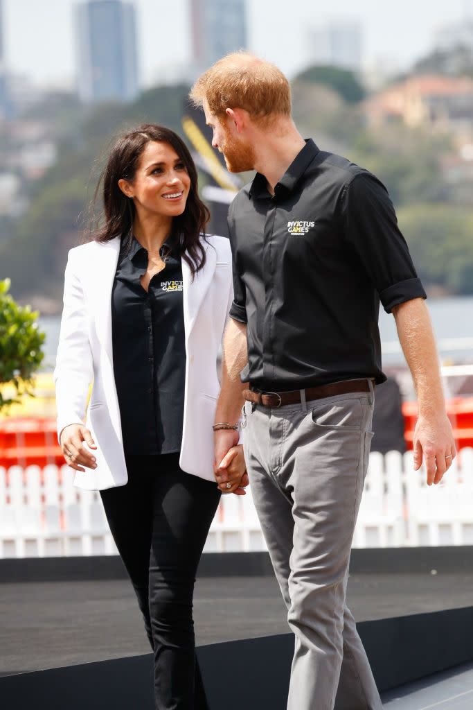 Harry and Meghan hold hands as they arrive to JLR Drive Day.