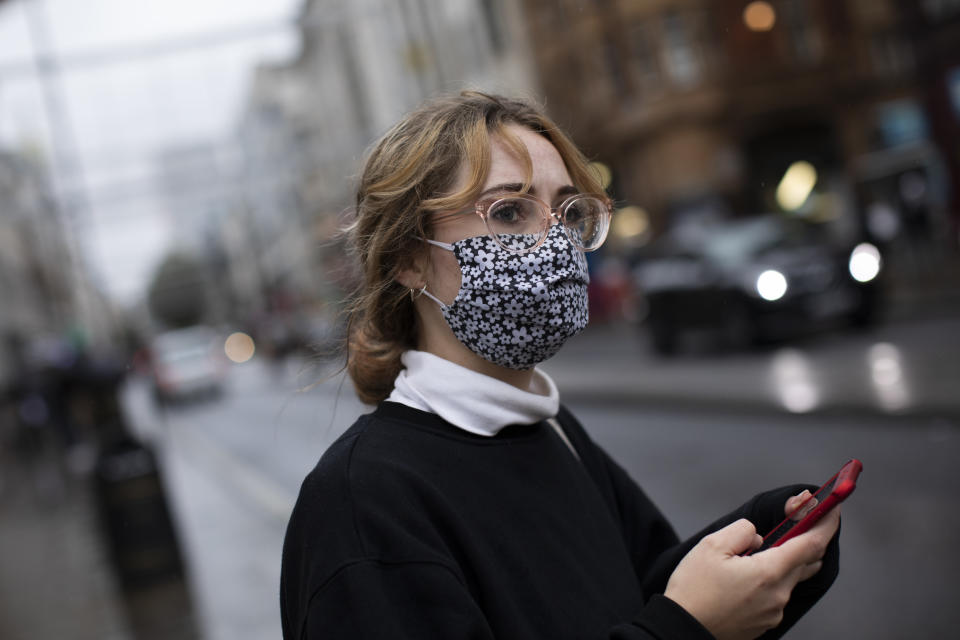 LONDON, ENGLAND - OCTOBER 13: A woman wears a face mask while passing through Oxford Circus on October 13, 2020 in London, England. London Mayor Sadiq Khan said today that the city would move into Tier 2 of the government's new Covid-19 risk classification once it hits 100 new daily cases per 100,000 people, which could happen this week. The second or "high" tier of the three-tier system triggers a ban on household mixing, although pubs would remain open. (Photo by Dan Kitwood/Getty Images)