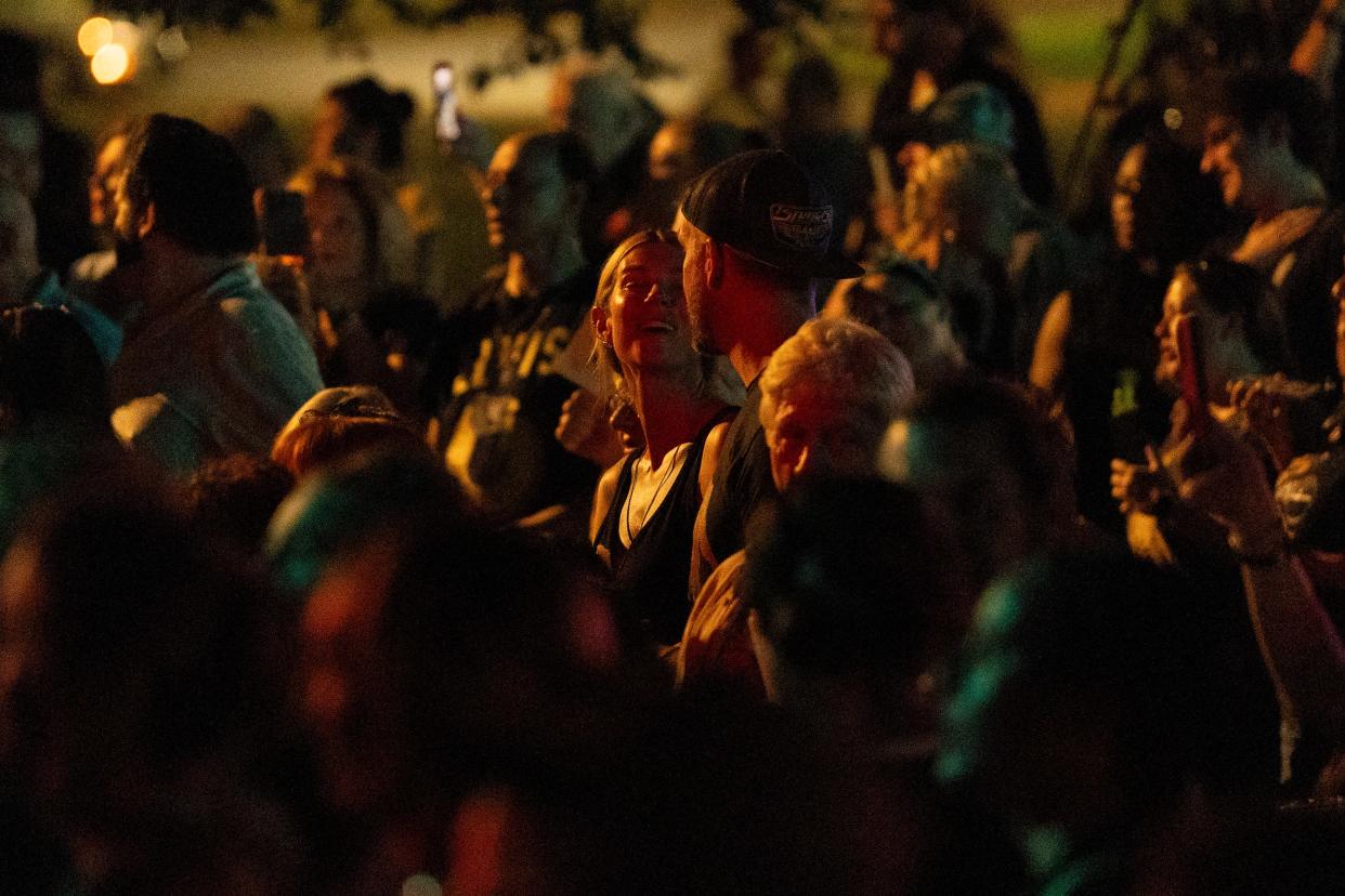 A couple sings “Can’t Help Falling in Love” to each other on Elvis Presley Boulevard in front of the gates of Graceland during the annual Candlelight Vigil to honor Elvis Presley in Memphis, Tenn., on Thursday, August 15, 2024.