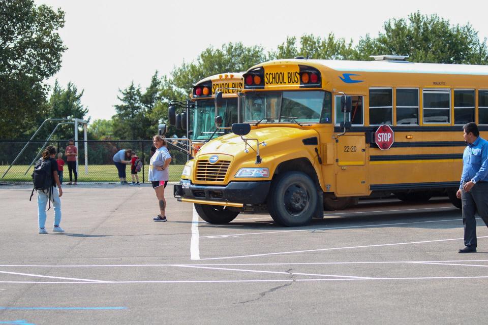 Bus driver Bobby Base (middle) talks to Southeast of Saline students as they load buses after school.