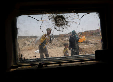 Displaced Iraqis flee during a fight between Iraqi Counter Terrorism Service forces and Islamic State militants in western Mosul. REUTERS/Danish Siddiqui